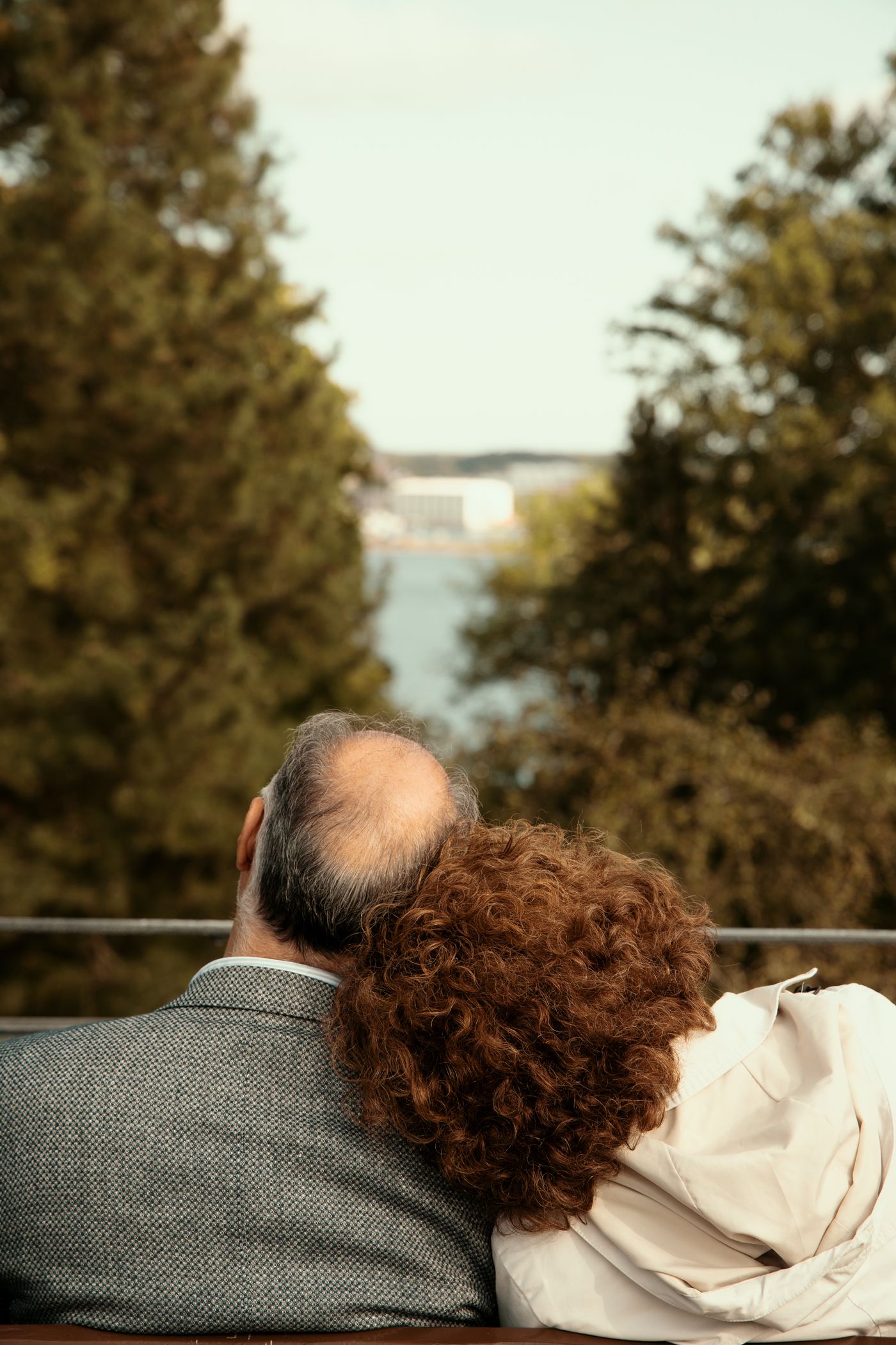 A couple sitting together on a bench outdoors